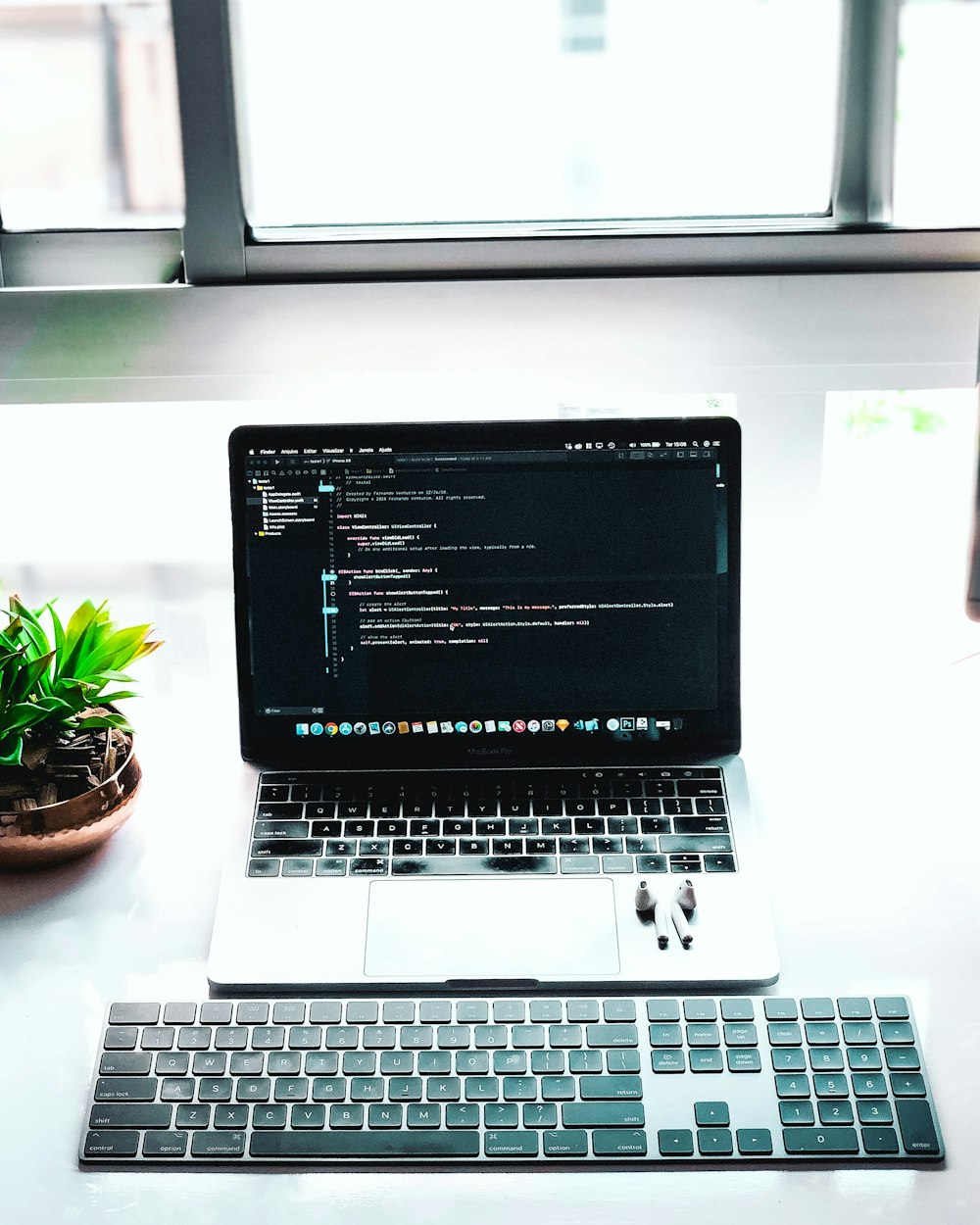 silver and black laptop beside keyboard on table