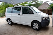 A clean, well-maintained medical transport van parked outside a medical clinic in Hawaii.