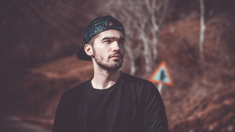 man in black top wearing black cap