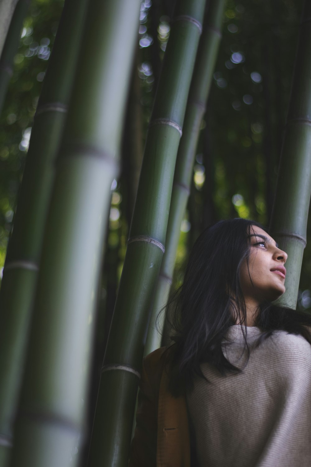 smiling woman leaning on bamboo tree