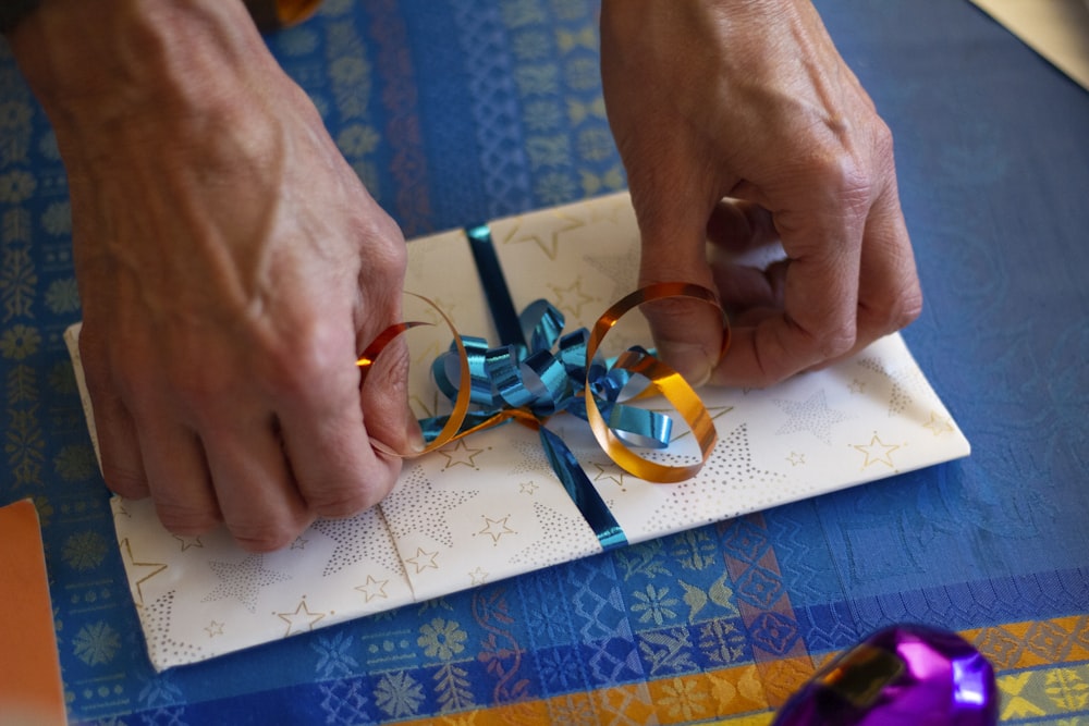 person putting ribbon on card