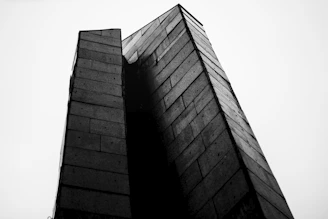 Black-and-white photo of a geometric concrete structure in Kinshasa, capturing raw textures and sharp shadows.