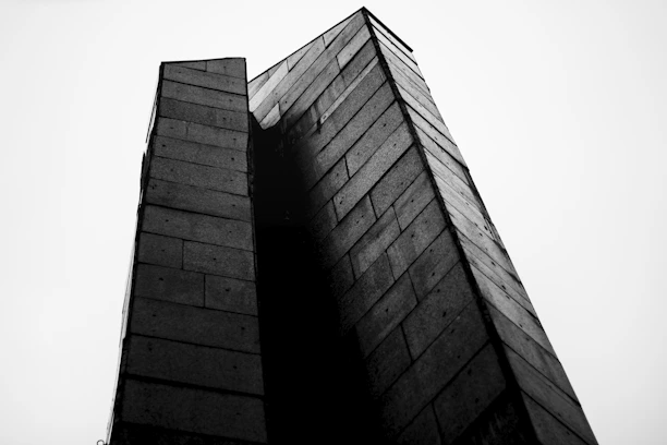 Black-and-white photo of a geometric concrete structure in Kinshasa, capturing raw textures and sharp shadows.