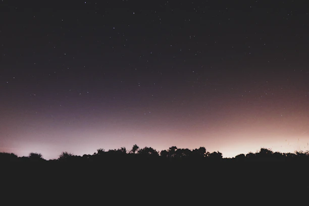 A serene night sky filled with stars and subtle cosmic symbols glowing softly.