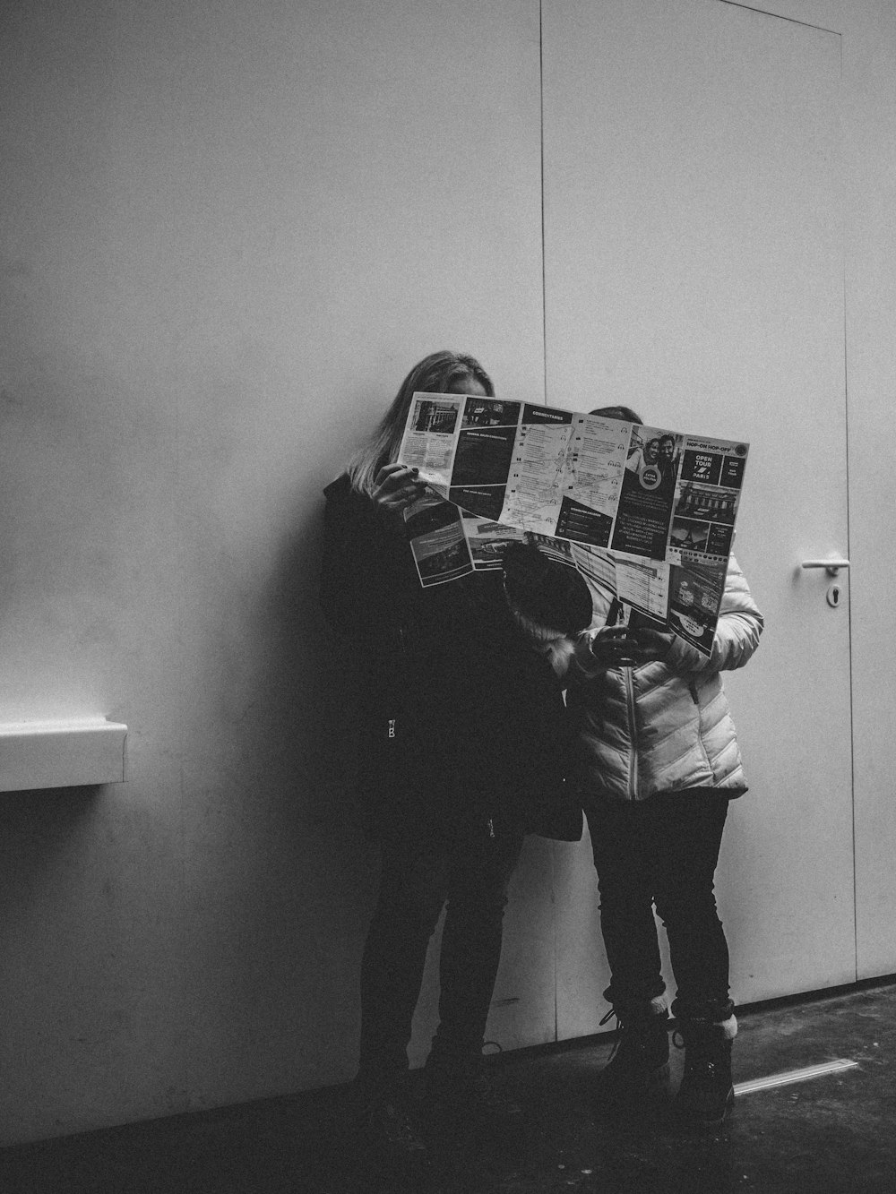 two woman holding newspaper