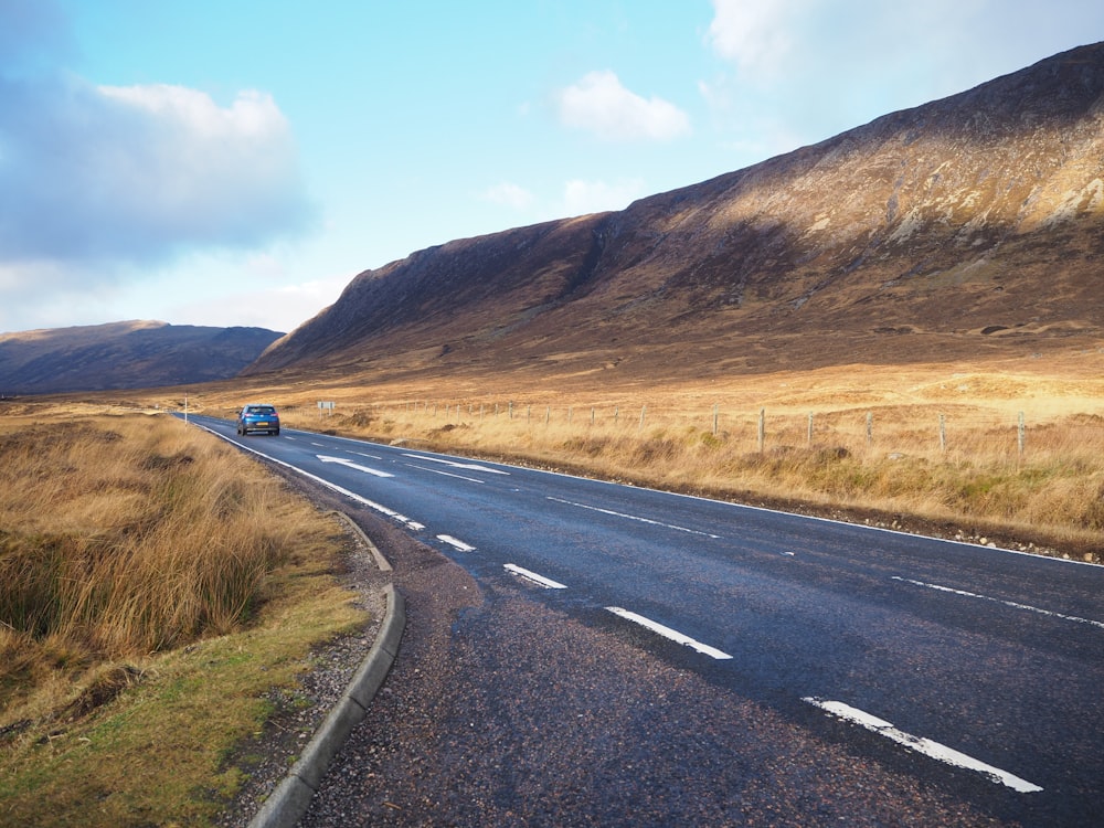 black car travelling on road during daytime