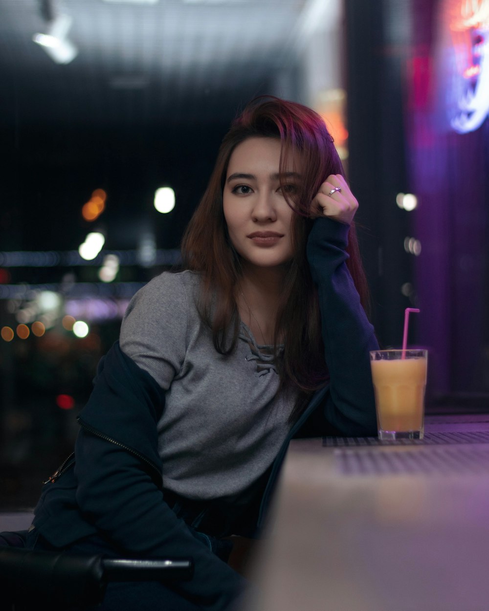 woman holding her hair sitting beside table