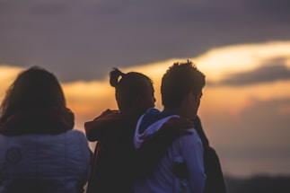 A diverse group of four happy people smiling together at sunrise.