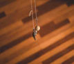 A set of colorful 3D printed keychains hanging on a stylish wooden hook against a white wall
