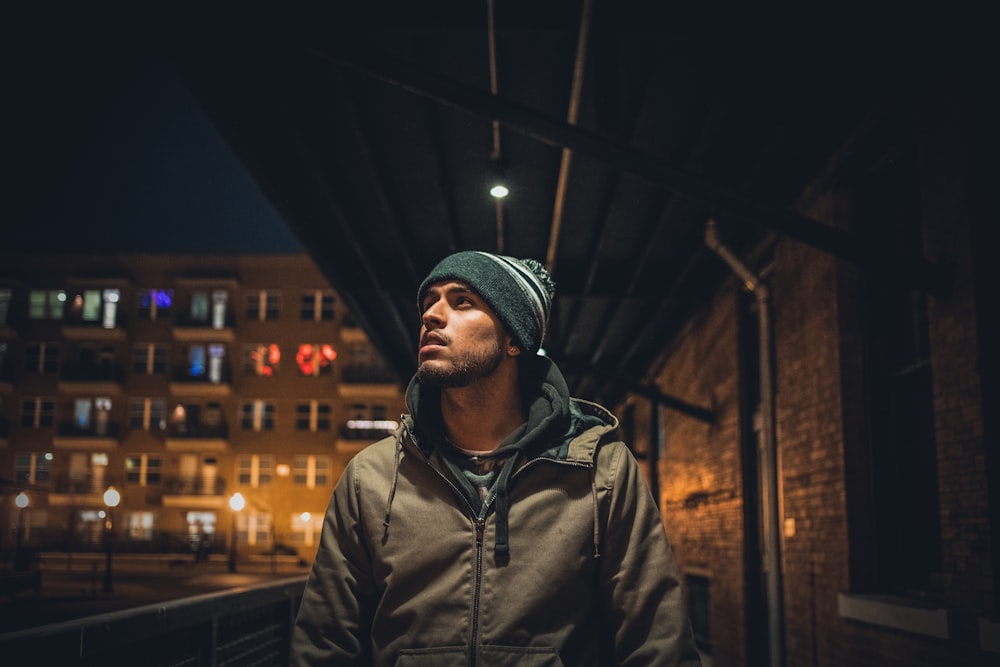 man in brown coat under waiting shed