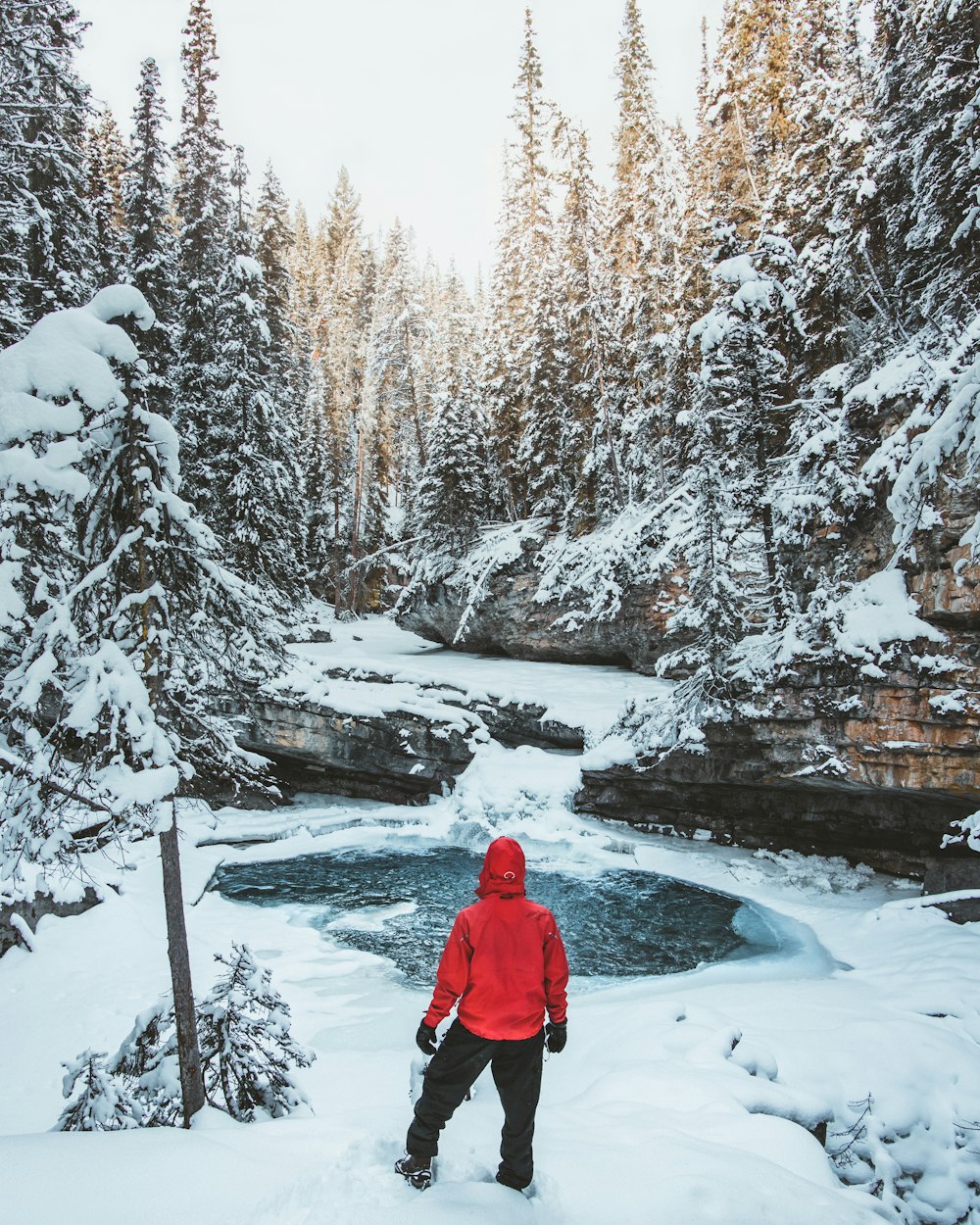 person in blue hoodie standing on ground covered by snow during daytime