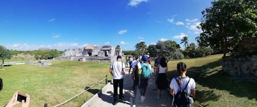 A group of happy travelers enjoying a guided walk through ancient ruins with detailed explanations.
