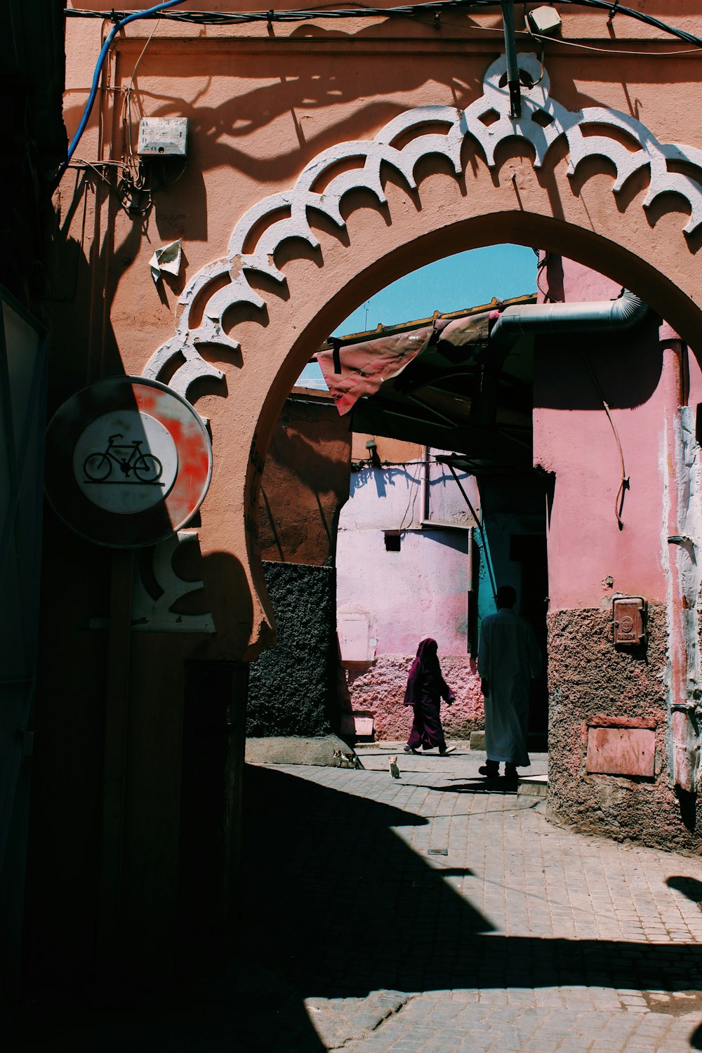 man standing beside pink house