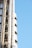 A section of a modern building featuring exposed steel pipes and structural elements against a clear blue sky.
