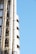 A section of a modern building featuring exposed steel pipes and structural elements against a clear blue sky.