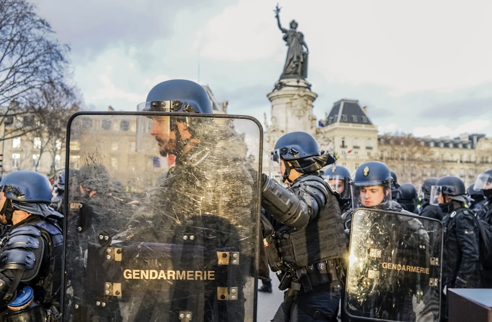 policemen holding clear shields near statue
