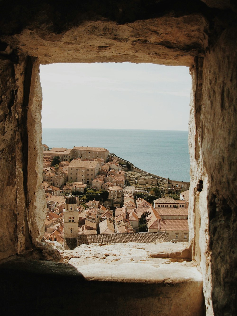 window view on concrete buildings facing ocean