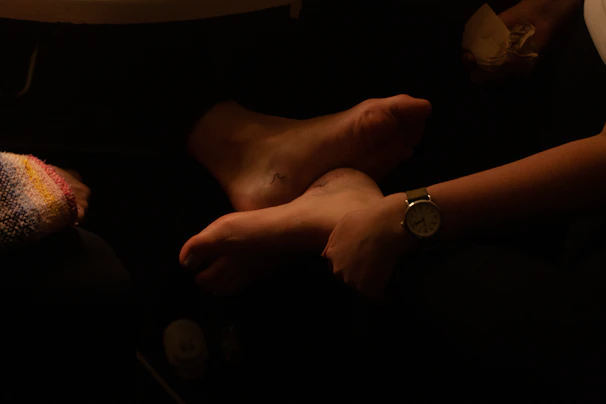 A physiotherapist gently examining a patient's foot in a cozy clinic room.