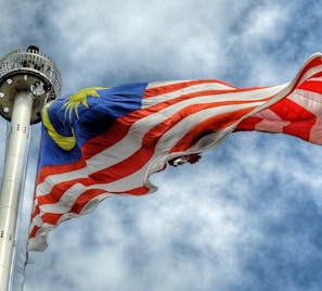 low angle photography of waving flag of Malaysia during daytime