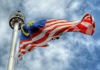 low angle photography of waving flag of Malaysia during daytime