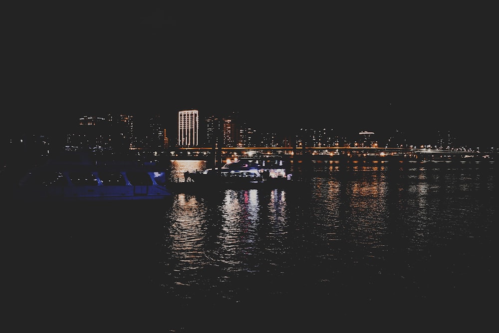 un barco flotando sobre un cuerpo de agua por la noche