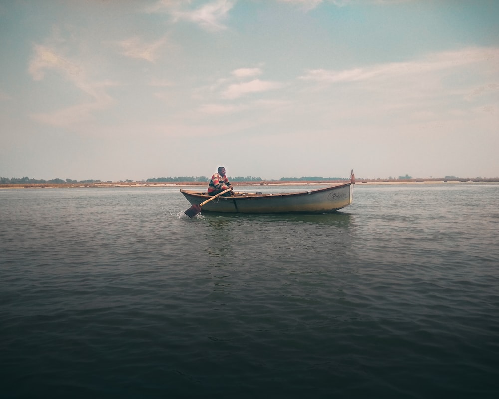man in boat on a calm water