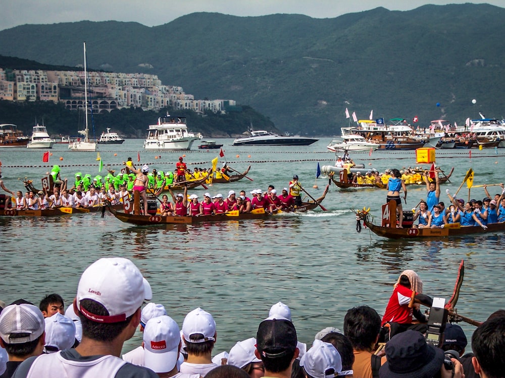 people watching dragon boat competition during daytime