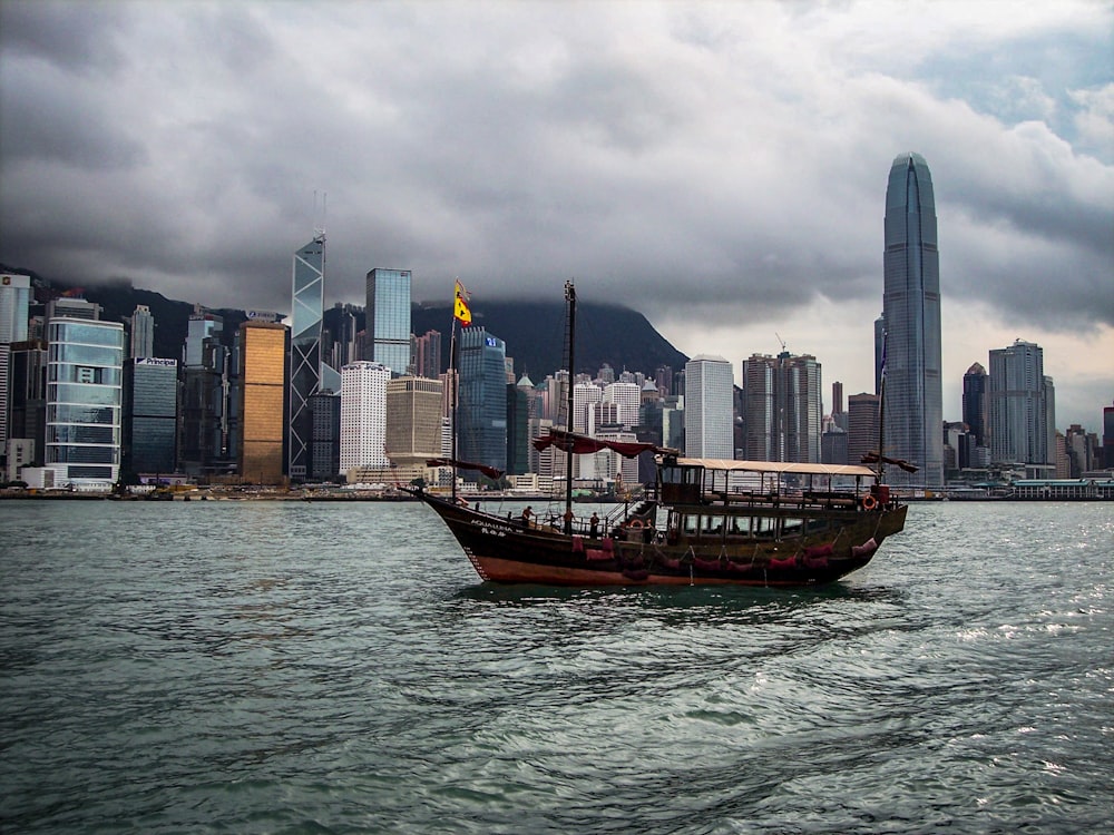 boat on water beside high-rise buildings