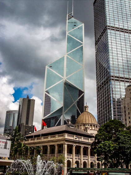 dome building beside glass high-rise building under gray sky