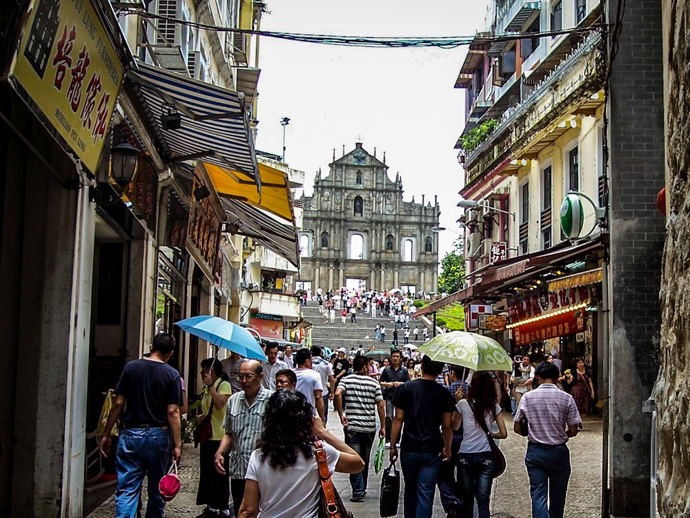 a group of people walking down a street with umbrellas