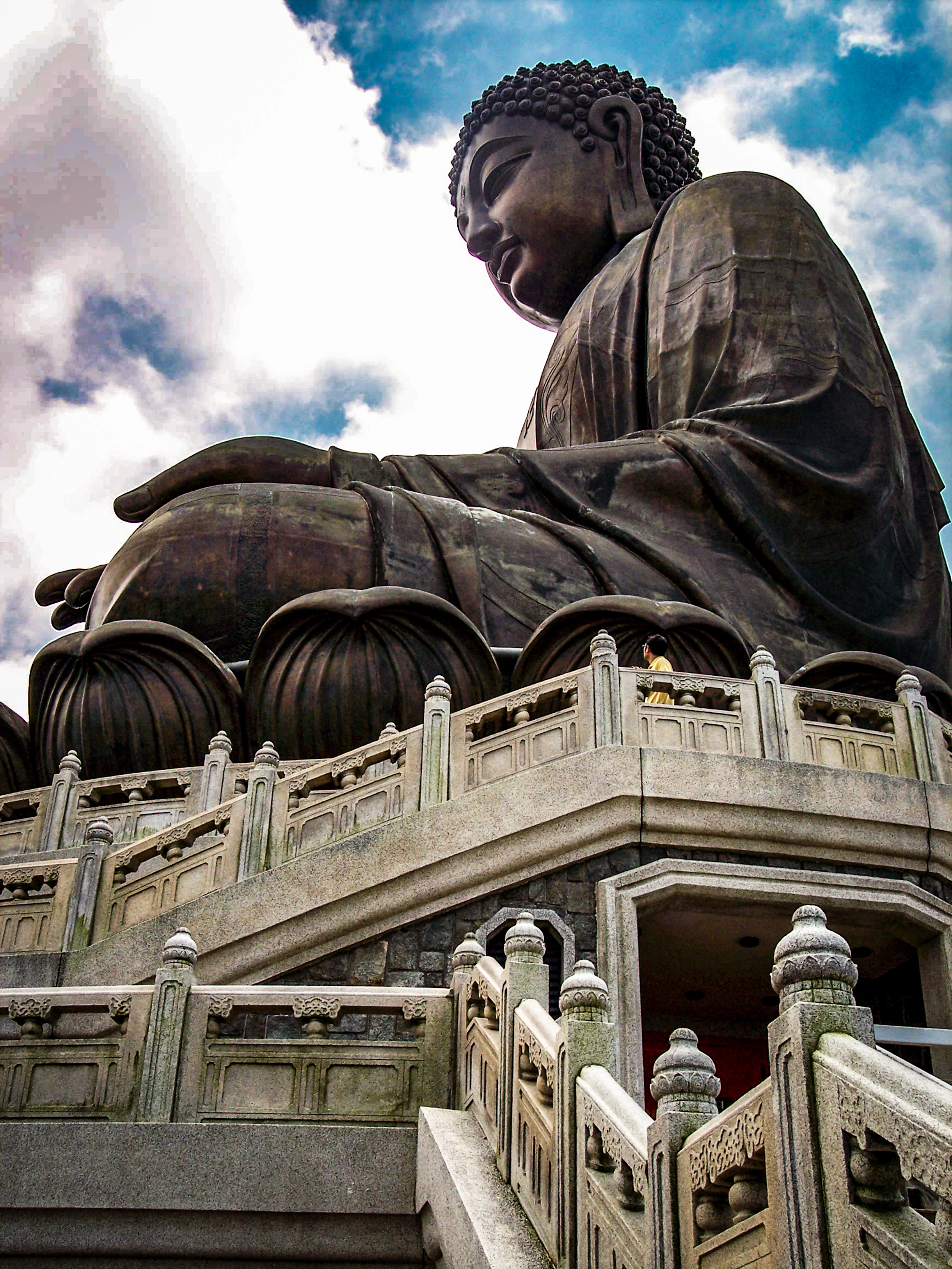 The bronze Tian Tan Big Buddha seated on its lotus above the stone balustrades and stairway at Ngong Ping on Lantau Island