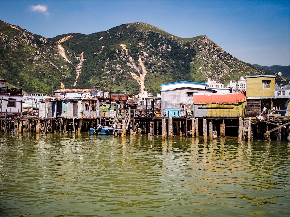 a body of water with houses and mountains in the background