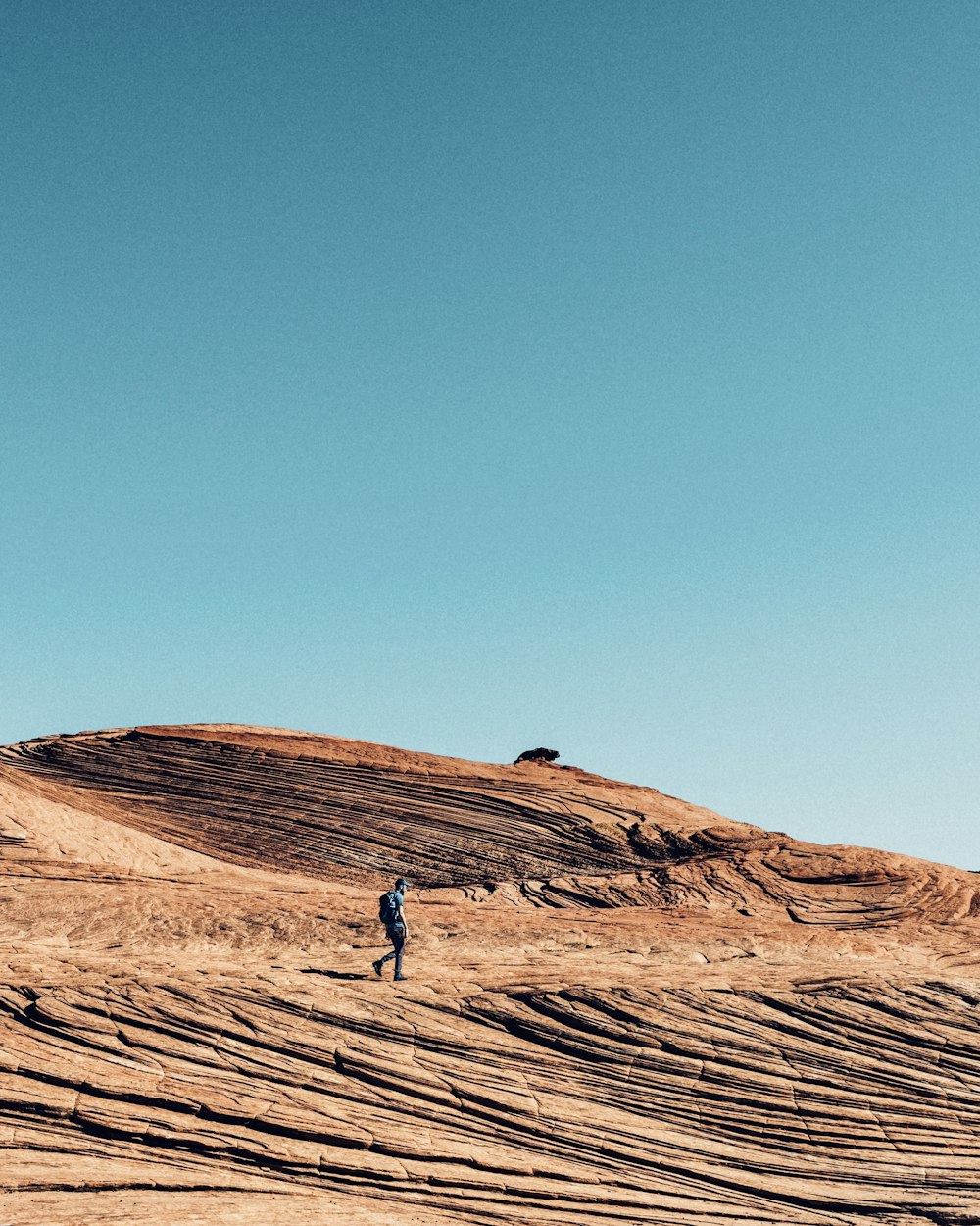 man walking on sand dune during daytime