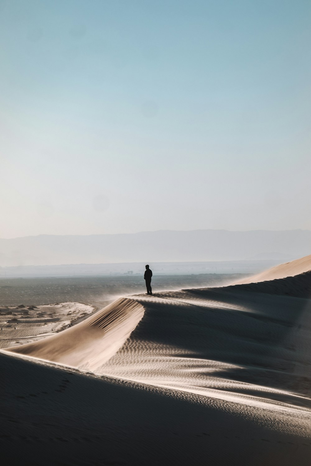 Persona in piedi sul deserto durante il giorno