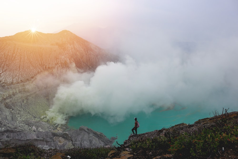 person standing beside lake