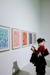 woman standing in front of paintings