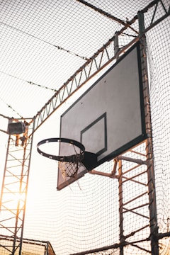 Workers fitting a protective net around a basketball court.