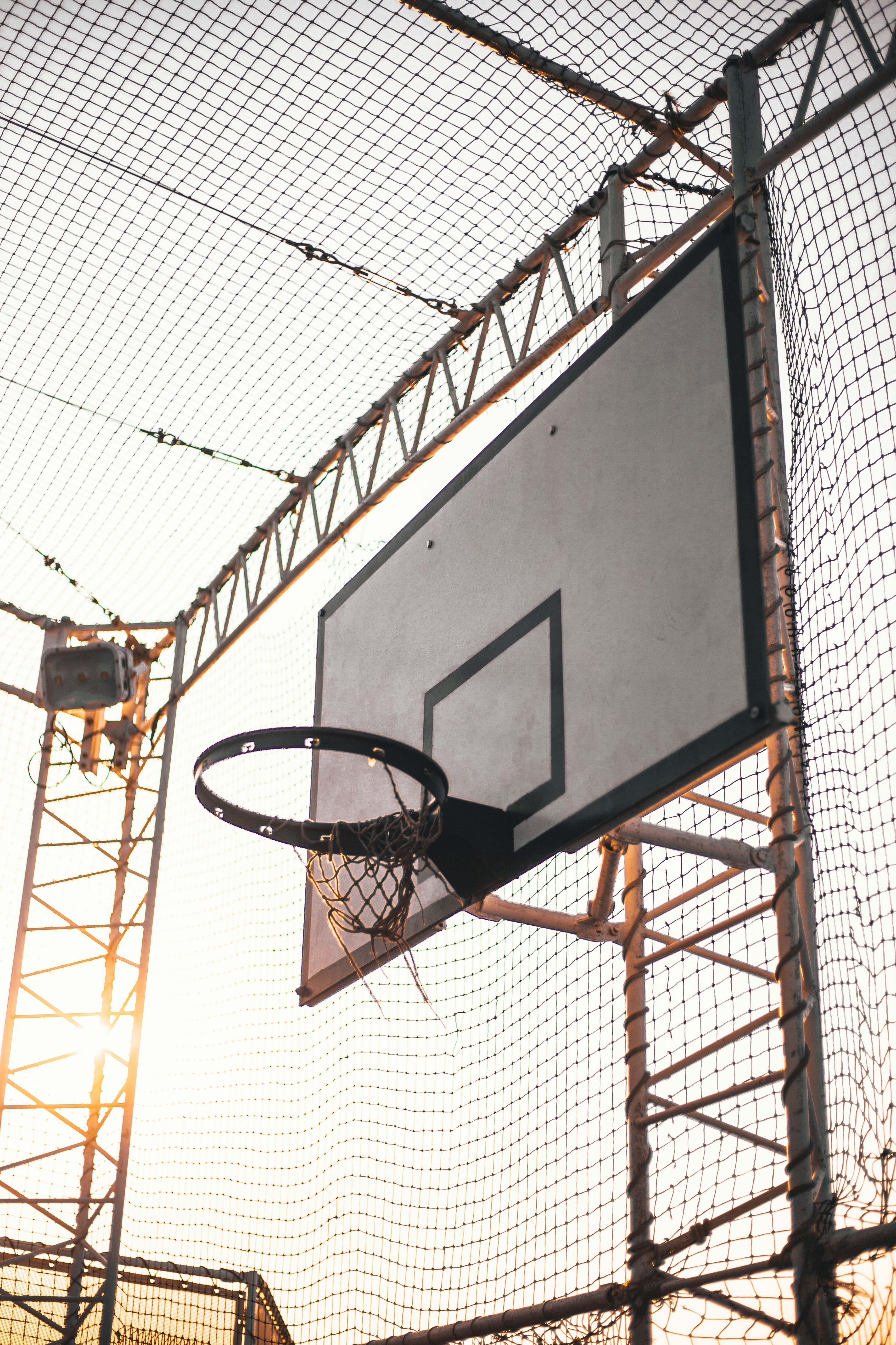 grey basketball system inside net covered court