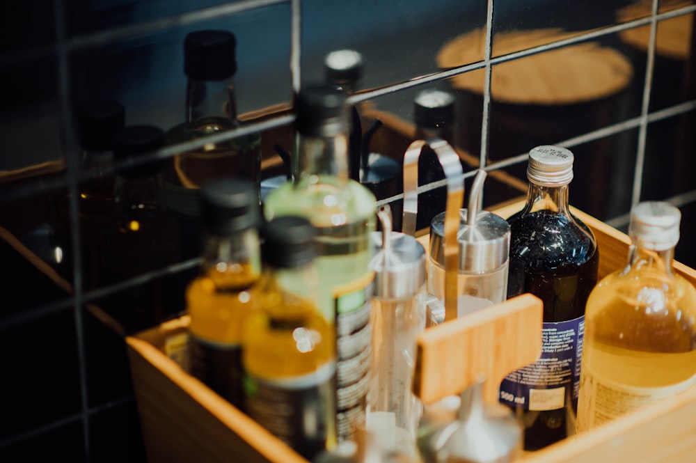 assorted glass bottles on brown wooden basket