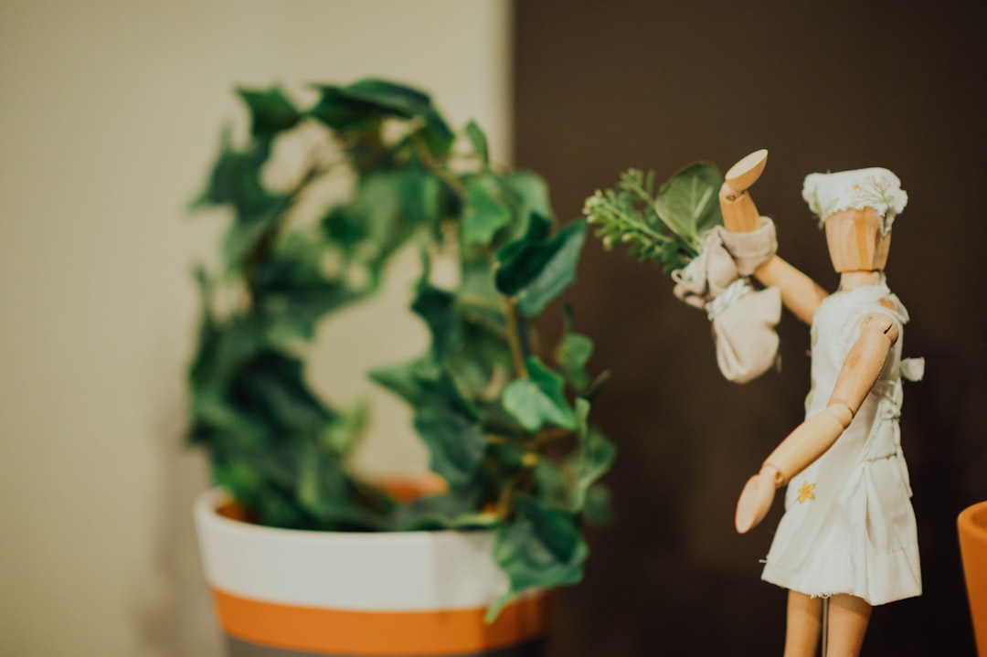 shallow focus photo of wooden figure near plants