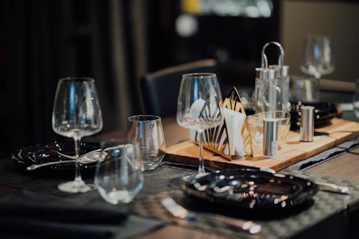 A cozy dining setup in a home with black plates arranged elegantly on a dark wood table.