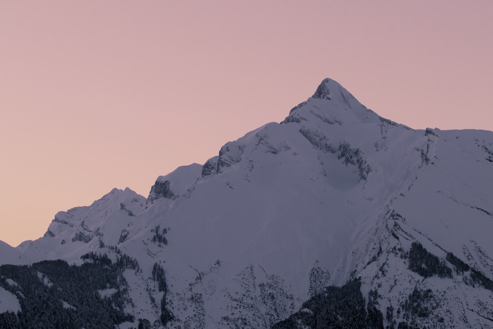 snow covered mountain during sunset