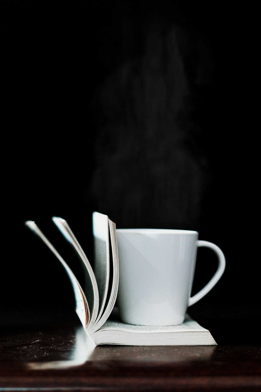white ceramic mug on white book