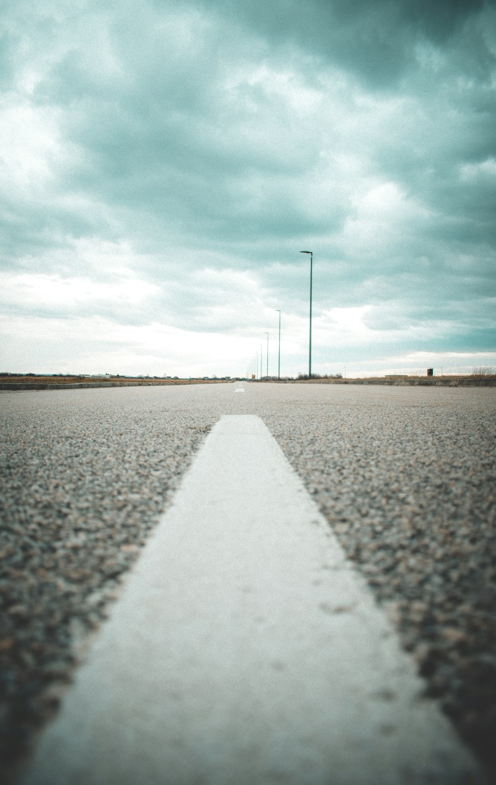 Breite Straße unter bewölktem Himmel