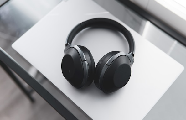 gray and black wireless headphones on desk