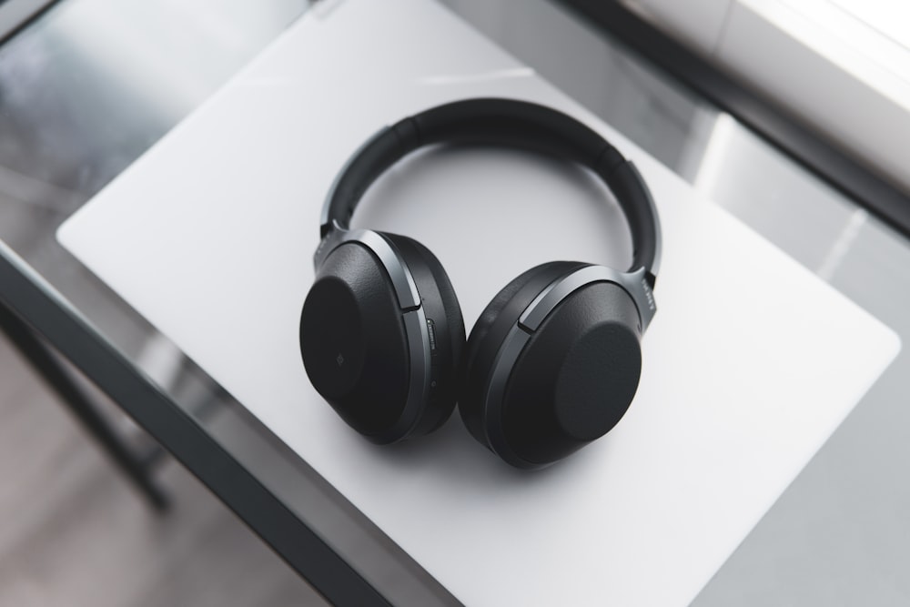 gray and black wireless headphones on desk