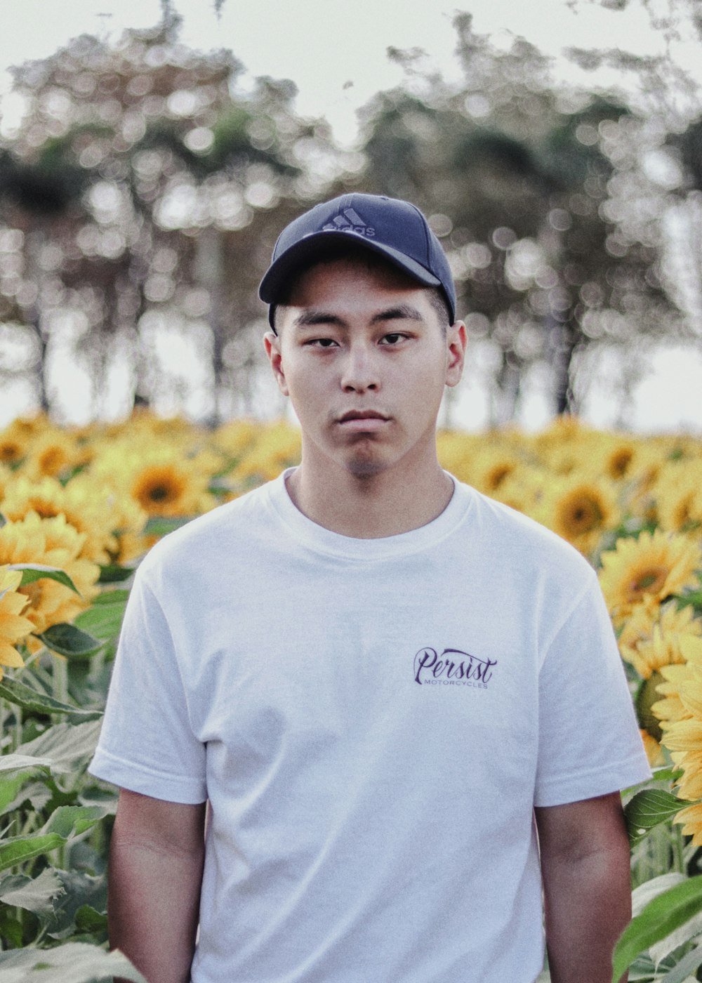 man in white crew-neck T-shirt wearing cap