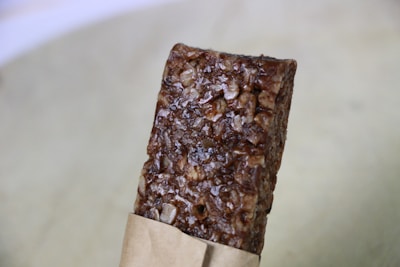 A close-up of a protein bar with nuts and chocolate.