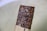 A close-up of a hand holding a granola bar with nuts and seeds visible.