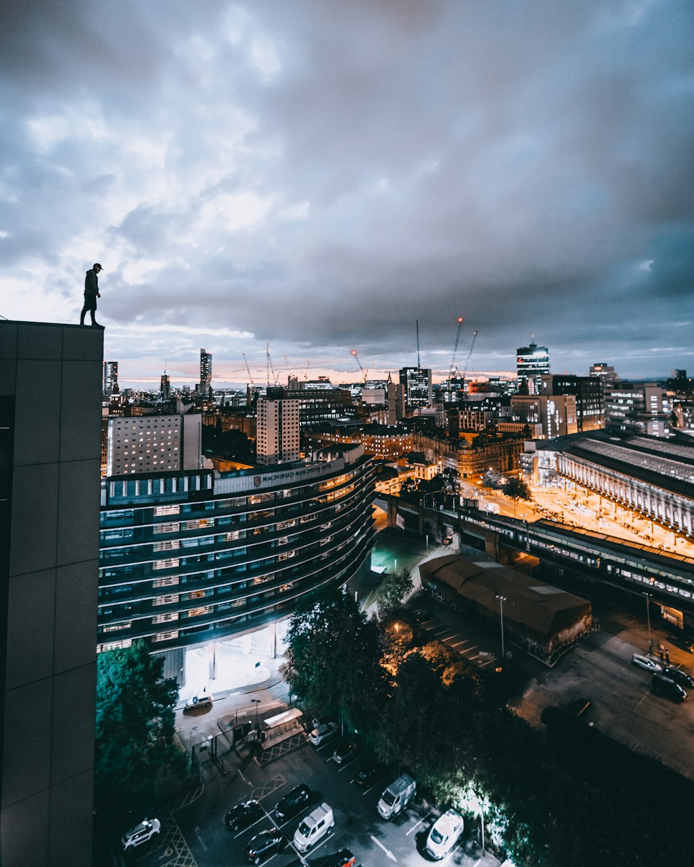 man in black top standing on rooftop